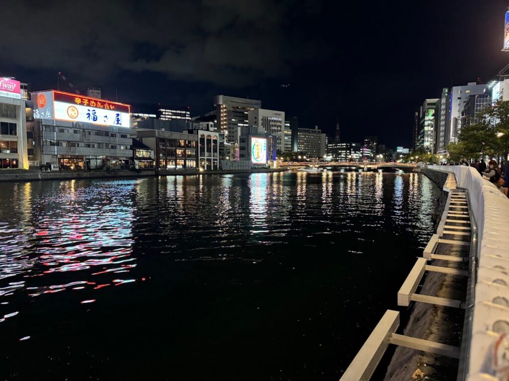 ネオンが水面に映る夜の福岡の川沿い