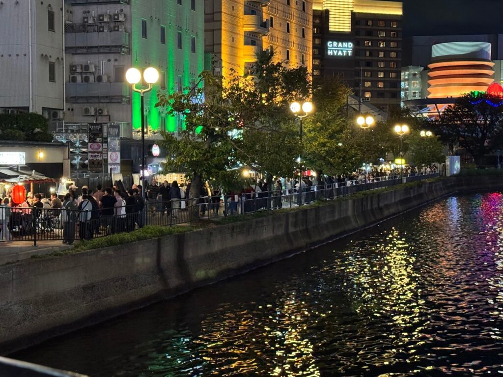 夜の川沿いに明かりが灯る屋台街